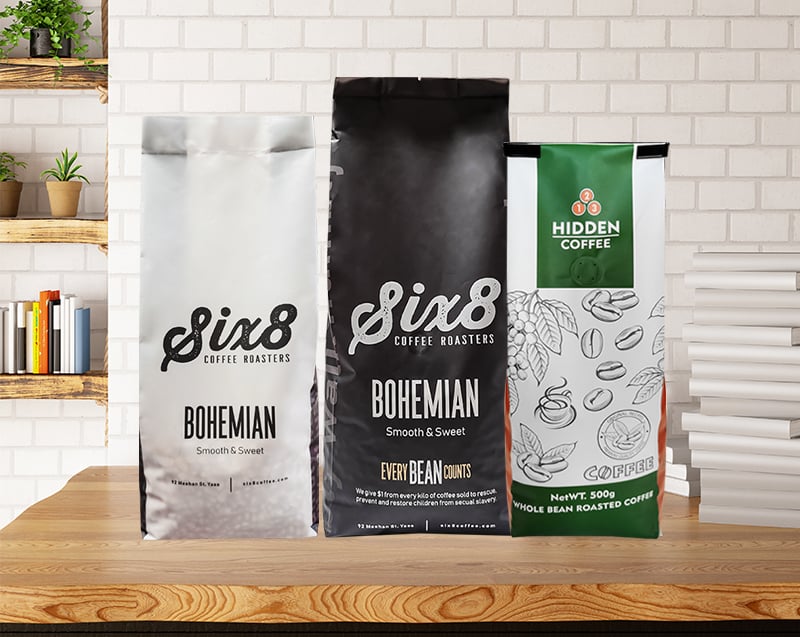 Three custom printed side gusset coffee bags displayed on a counter