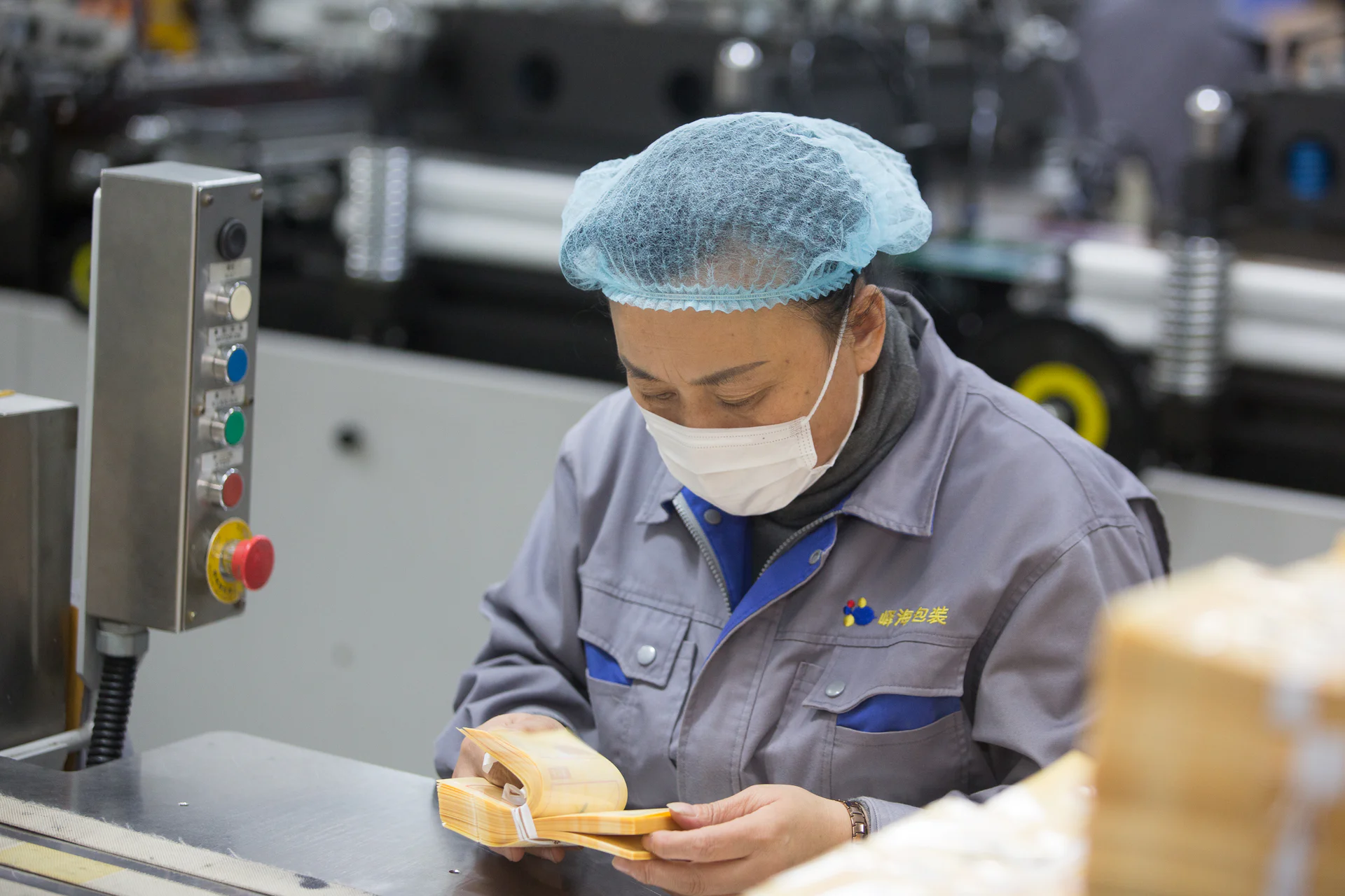 Operator manually inspecting finished flexible pouches