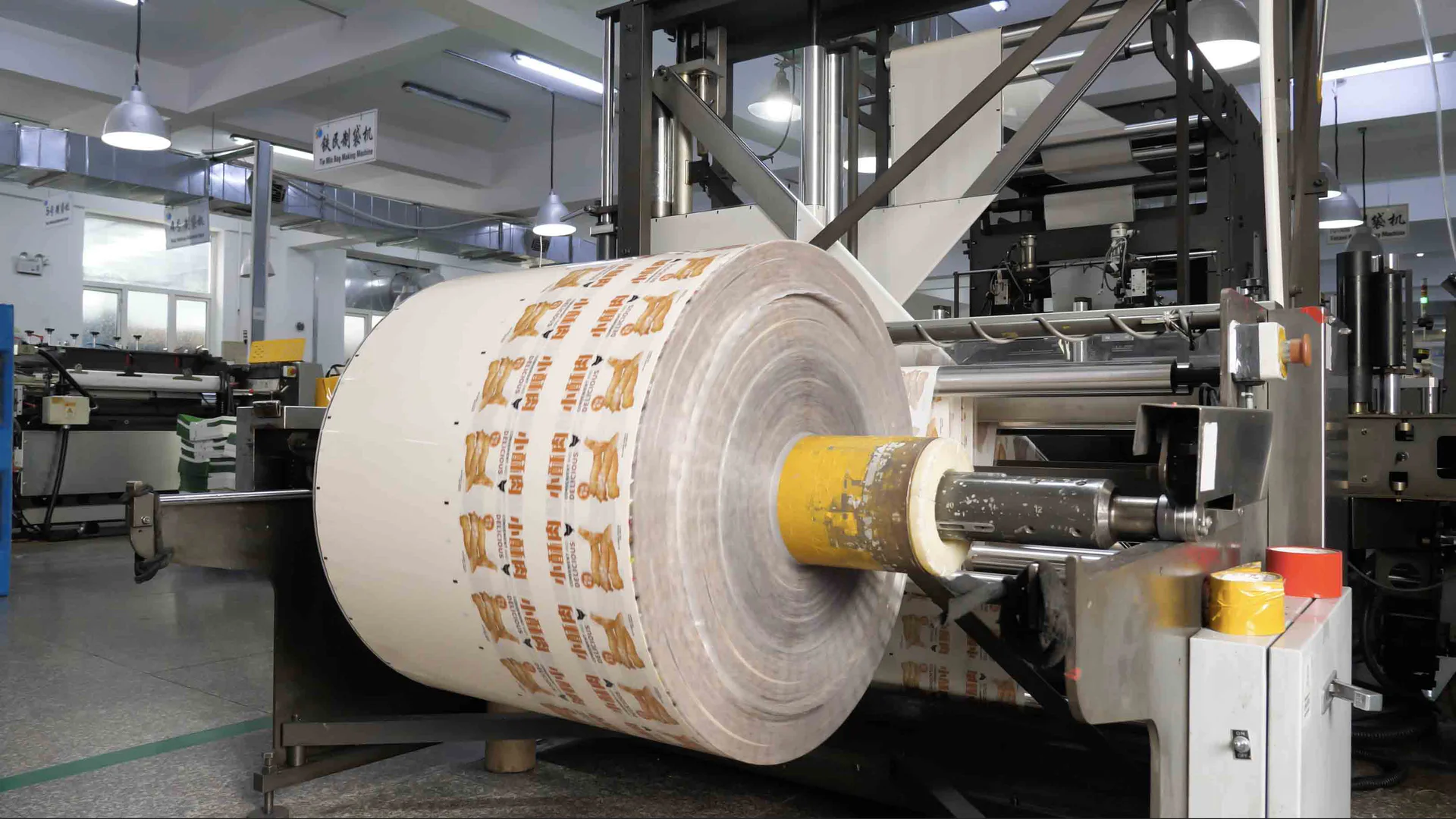 Printed packaging film roll positioned on converting equipment